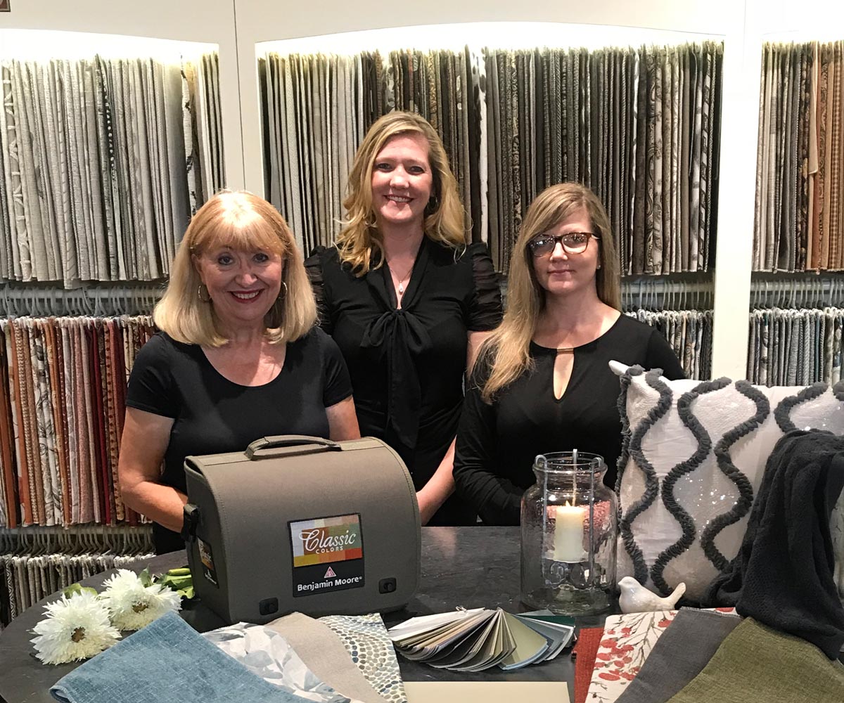 Three women in a furniture showroom promoting The Granary warehouse shopping experience.