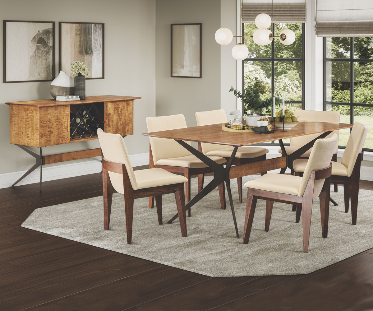 Wood dining table with upholstered chairs in a bright modern dining room.